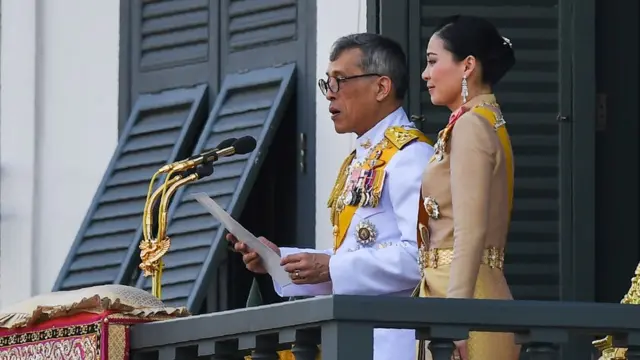 King Maha Vajiralongkorn makes a speech beside Queen Suthida from the balcony of Suddhaisavarya Prasad Hall of the Grand Palace