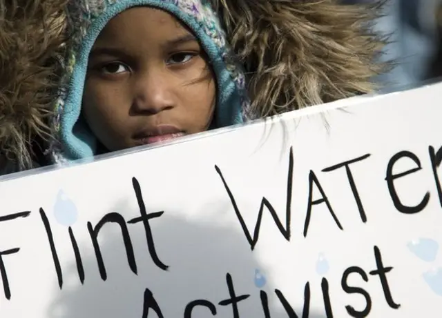Niño protestando en Flint.