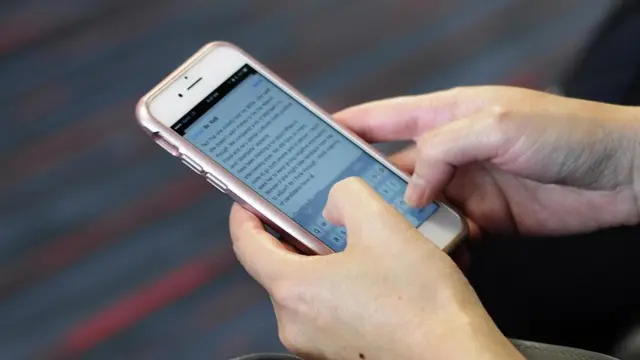 Mulher lê e-mail no celular