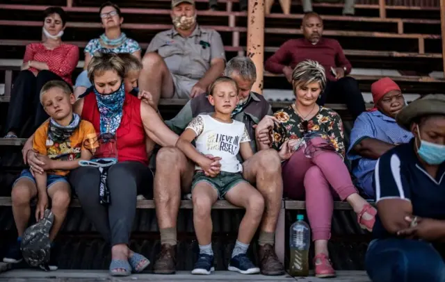A family hold hands as they collect themselves in prayer while taking part in a special mass prayer meeting in Senekal, on October 14, 2020.