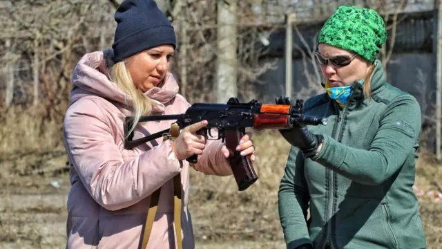 Umugore w'umusivile (ibumoso) arimo gutozwa na mugenzi we kurasa mu mujyi wa Odesa wa Ukraine