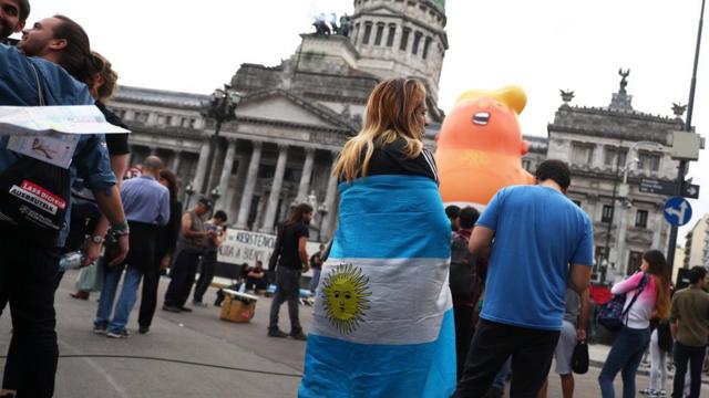 People gather near the "Baby Trump" balloon ahead of the G20 leaders summit, in front of the Congress building in Buenos Aires, Argentina, 29 November