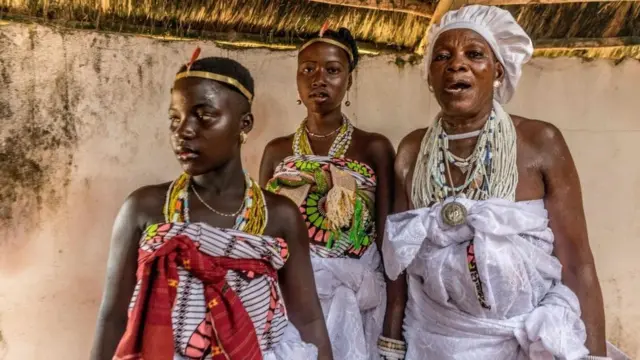 Des adeptes du vaudou sont vus dans une hutte avant un rituel vaudou lors du festival du vaudou à Ouidah, au Bénin, le 10 janvier 2022.