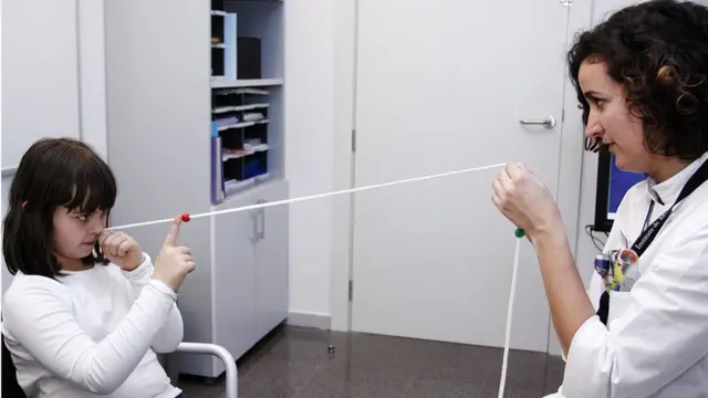 Niña y optometrista haciendo un ejercicio de terapia visual