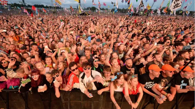 festivalgoers watch the Pyramid Stage at Glastonbury Festival. - 2017