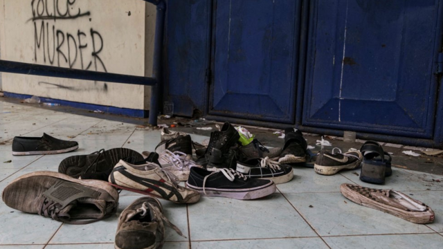 Обувь, оставшаяся после давки на поле стадиона Канджурухан 3 октября 2022 года в Маланге, Индонезия