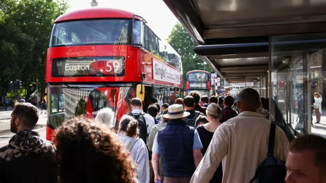 Passengers queue for bus during di rail strike