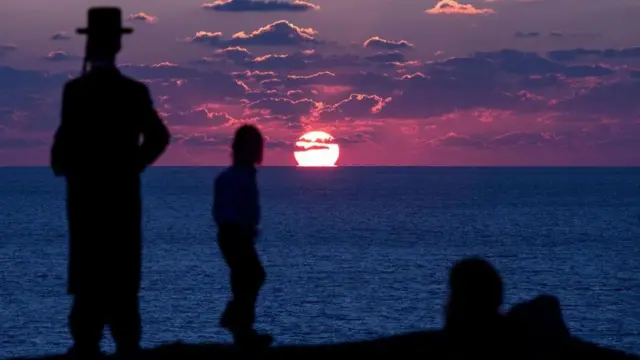 Judíos ultra ortodoxos participando en el ritual de Tashlich ritual, durante el que los pecados se lanzan al agua y los peces.