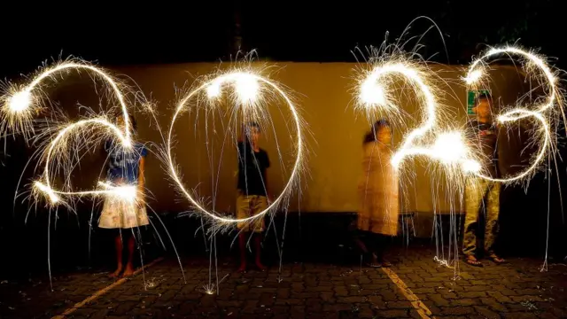 Jovens do Sri Lanka escrevendo '2023' com fogos de artifício durante as celebrações da véspera de Ano Novo em Colombo, Sri Lanka, em 31 de dezembro de 2022