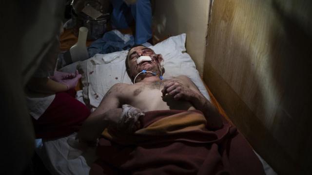 Медики оказывают помощь мужчине, раненому в результате обстрела города, 4 марта 2022 года (фотография Мстислава Чернова)