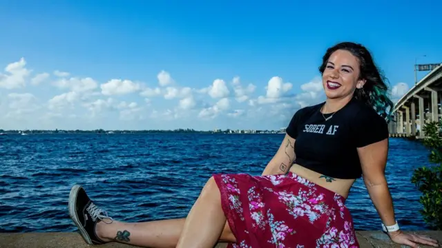 Kelly Fitzgerald, digital sobriety influencer, posing for a picture by the sea