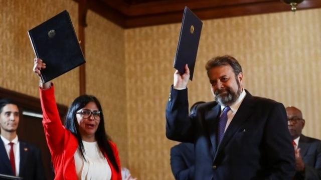 Delcy RodrÃ­guez, Vice President of Venezuela, and opposition deputy Timoteo Zambrano hold an agreement signed during the presentation of a national dialogue board in Caracas, Venezuela, 16 September 2019.