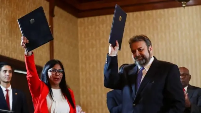 Delcy RodrÃguez, Vice President of Venezuela, and opposition deputy Timoteo Zambrano hold an agreement signed during the presentation of a national dialogue board in Caracas, Venezuela, 16 September 2019.