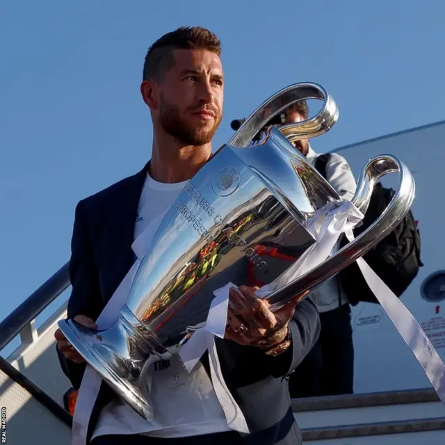 Sergio Ramos gets off the plane clutching the Champions League trophy