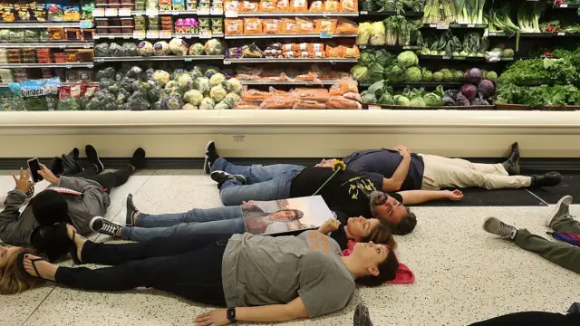 Manuel Oliver y Patricia Padauy protestan acostados en un supermercado.