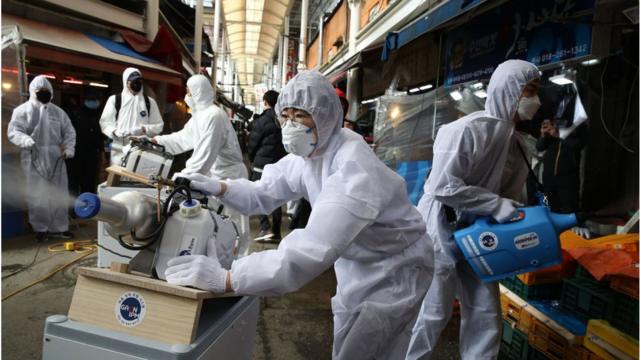 Disinfection professionals wearing protective gear spray anti-septic solution against the coronavirus (COVID-19) at a traditional market on February 26, 2020 in Seoul, South Korea