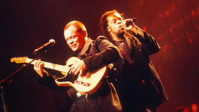 Ali Campbell na Astro bariko baririmba mw'ijoro mu gisagara ca Antwerp mu Bubirigi mu 2000