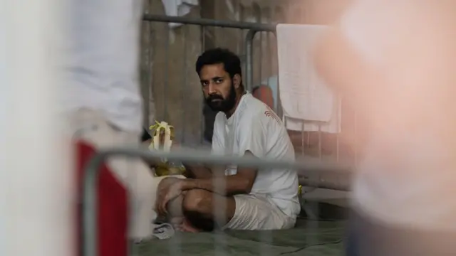 Un sobreviviente del naufragio sentado en una cama dentro de un refugio temporal en Kalamata, Grecia