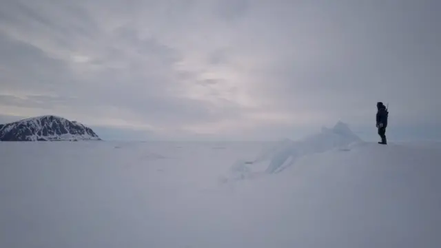 Un hombre de pie en la nieve.