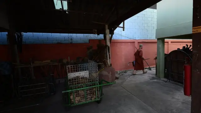 ภิกษุณีรูปหนึ่งเดินถือจอบเพื่อไปใข้ปรับปรุงพื้นดิน