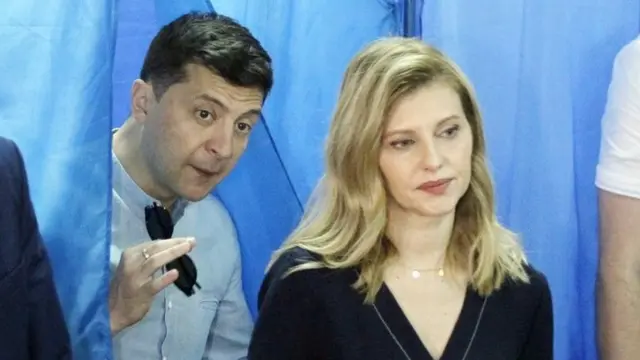 Ukrainian President Volodymyr Zelensky (left) leaves a voting booth in Kiev while his wife Olena waits. Photo: 21 July 2019