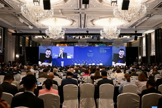 Các bộ trưởng và đại biểu lắng nghe bài phát biểu của Tổng thống Ukraine Volodymyr Zelenskiy