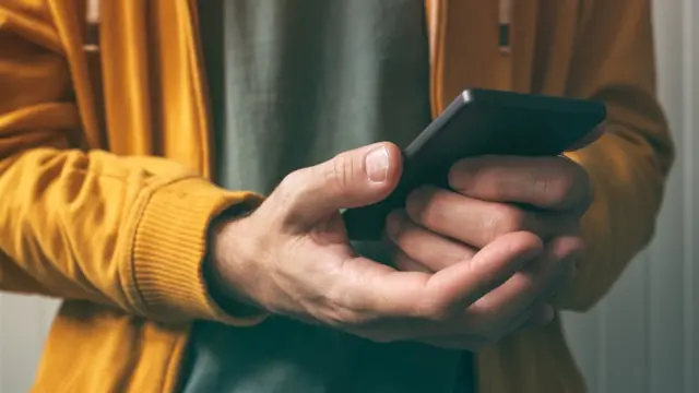 manos agarrando teléfono