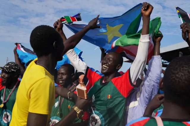 Des personnes ayant participé à la Grande Course du Sud-Soudan dansent et font la fête lors d'un concert au mausolée de John Garang à Juba, au Sud-Soudan.