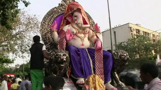 A statue of Lord Ganesh is paraded through the streets