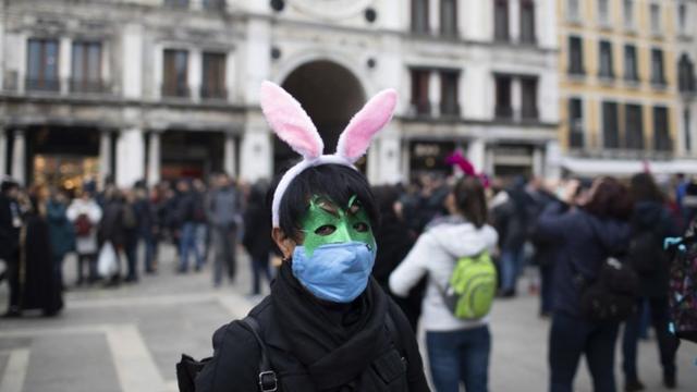 женщина в хирургической маске в Венеции на карнавале