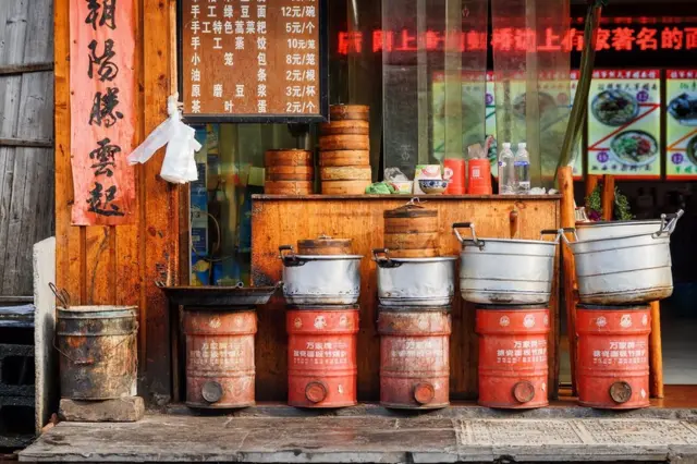 Cooking pots and Dim Sum baskets outside restaurant, China