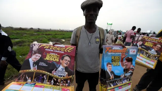 Un vendedor con carteles con fotografías del evangelista pentecostal alemán-estadounidense Reinhard Bonnke y su sucesor Daniel Kolenda.