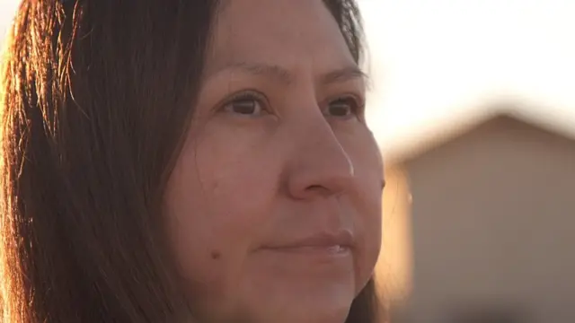 Bea Redfeather looks into the distance at the top of a hill near her home in Shiprock, New Mexico
