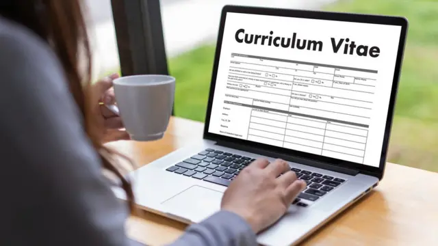 Umugore uri kunywa icyayi areba kuri CV kuri mudasobwa