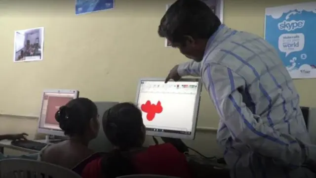 কম্পিউটারে ই-কমার্সের প্রশিক্ষণ নিচ্ছেন দু'জন