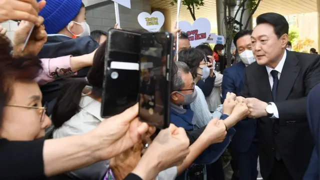 윤석열 대통령이 10일 취임식 참석을 위해 서울 서초구 사저를 나서면서 지역주민들과 인사하고 있다