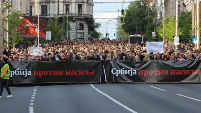 Thousands march behind a sign that reads 'Serbia against violence'