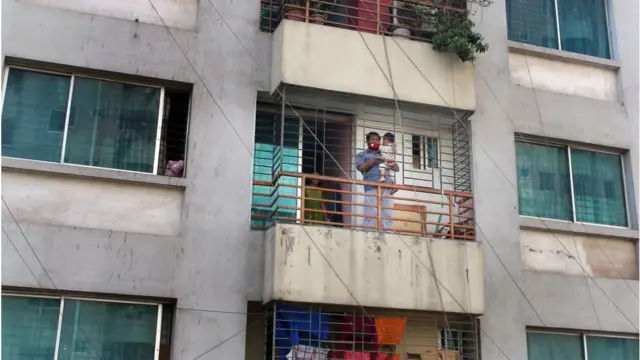 বারান্দায় দাঁড়ানো বাবা সন্তান।