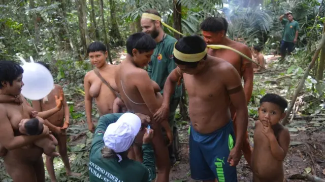 Enfermeira aplicando vacinapixbets futebolmulher kurubo com a família