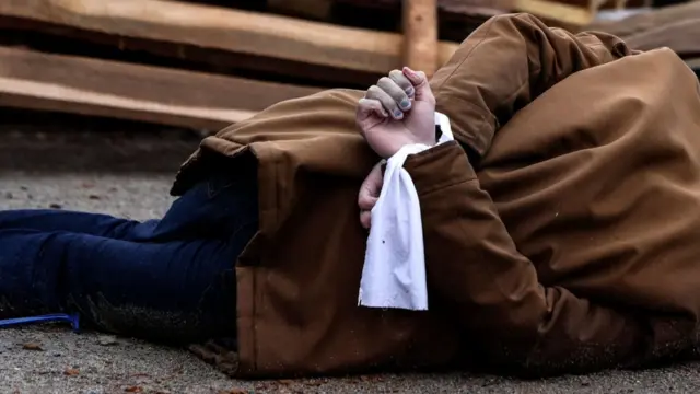 Un cuerpo yace en el suelo con las mandos atadas en Bucha.