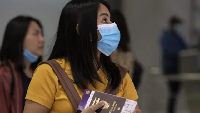 Mujer con barbijo y pasaporte