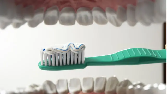 Cepillo de dientes a punto de entrar en la boca.