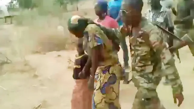 คนใส่ชุดทหารนำตัวผู้หญิงและเด็กไป