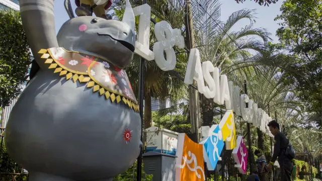 Pekerja memasang media promosi Asian Games 2018 di depan Balai kota, Jalan Medan Merdeka Selatan, Jakarta, Jumat (6/7). Pemerintah akan meningkatkan promosi Asian Games guna menggaungkan perhelatan olahraga negara-negara Asia yang dilaksanakan di Jakarta dan Palembang pada 18 Agustus-2 September mendatang.