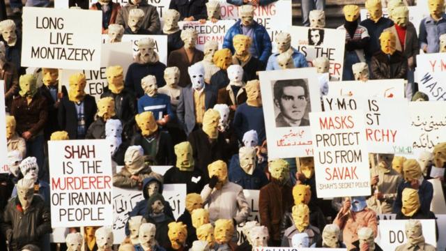 反对伊朗末代国王巴列维的示威者1977年在美国国会大楼前示威，其中一个标语说面罩可以保护他们，免受巴列维的秘密警察报复。