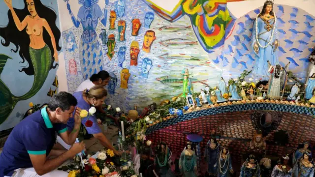 Awọn olujọsin n gbadura ni waju ojubọ kan ni eti odo Salvador, nipinlẹ Bahia, l'orilẹede Brazil nigba ọdun Yemanja (Iyemọja), oriṣa odo lati ẹsin abalaye Yoruba to jẹ ọkan lara awọn oriṣa to gbajumọ ju ninu aṣa awọn adulawọ nilẹ Brazil.