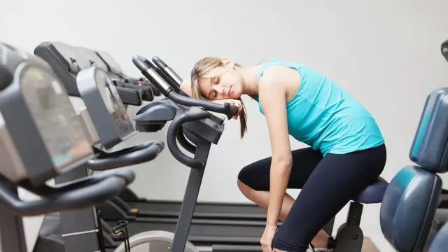 Mujer durmiendo en un gimnasio