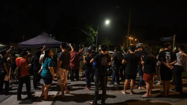 شرطة وصحفيون وماليزيون عاديون يتابعون دهم الشرطة لمنزل نجيب