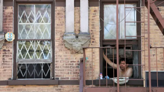 A man looks outside his window in New York
