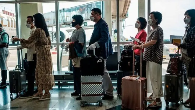 Baadhi ya raia wa kigeni waliowasili katika uwanja wa Entebbe nchini Uganda wakipiga foleni ya kukaguliwa